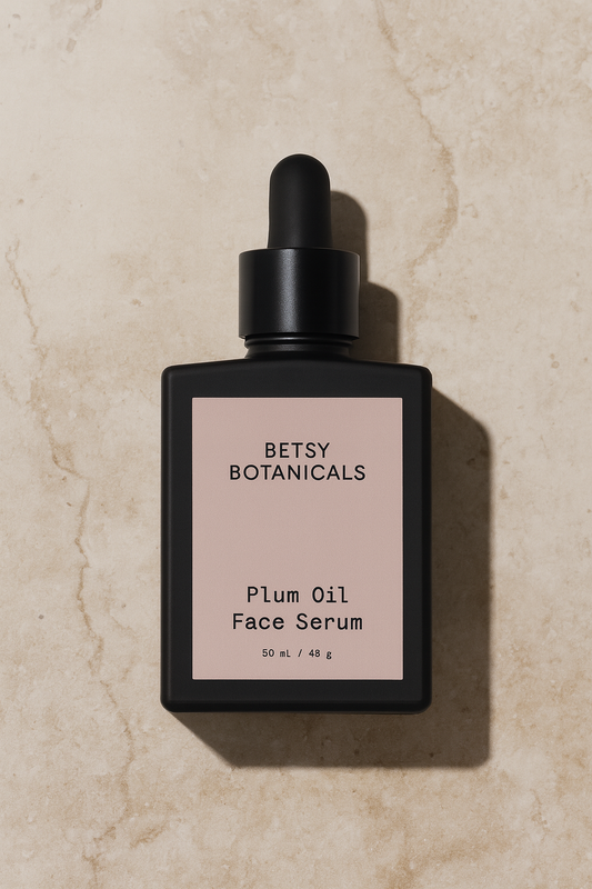 Betsy Botanicals Plum Oil Face Serum bottle on a beige marble background